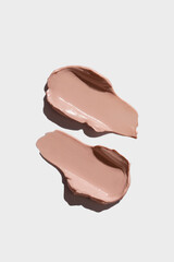 Cream texture cosmetic smear on white background. Make-up base. Skin toning cream.
