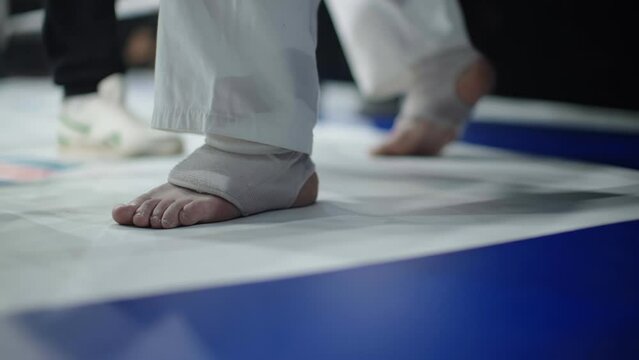 Legs of a karateka during a professional fight. Preparation for battle.