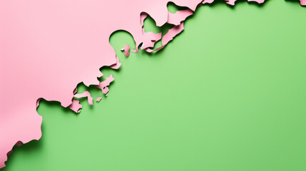 Green paper torn apart on a pink paper background