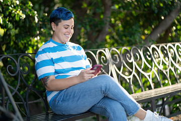 Androgynous Person Relaxing with Smartphone in Park