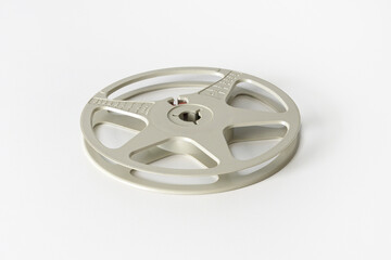 Obraz premium Empty reel to reel tape recorder or 8mm film reel. Cassette of a household film projector from the 60s-70s. White background, close-up