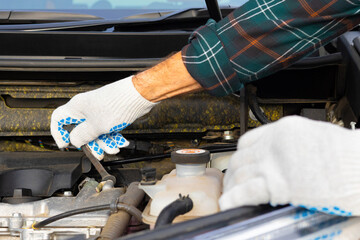 the driver unscrews the nut during the repair of the car.