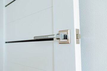 Close-up chrome door handle, built-in lock in the door. The latch tab is made of metal.