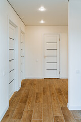 Bright entrance hall in the house, wooden parquet on the floor, interior of a country house, white bright room.