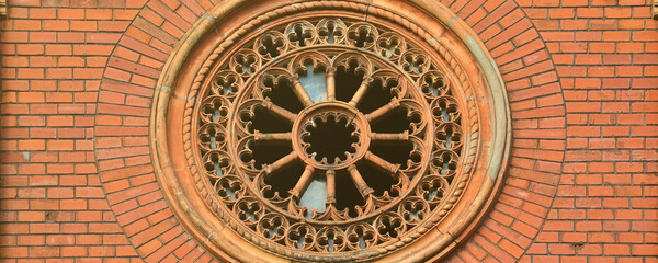 Texture front part of an ancient brick crypt with a round patterned carved window in the cemetery