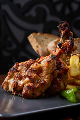 Close-up of a plate of grilled chicken thighs with mashed potatoes and rosemary