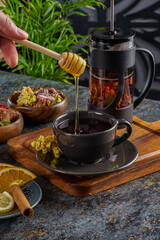 Traditional Turkish tea cup with copper and glass utensils and herbs with honey