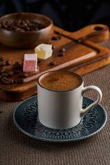 A cup of Turkish coffee on a dark background and wooden floor