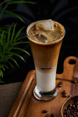 A cup of cold coffee on a dark background and wooden floor