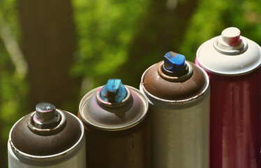 A few used aerosol paint sprayers lie on the windowsill in the workshop of a graffiti artist. The...