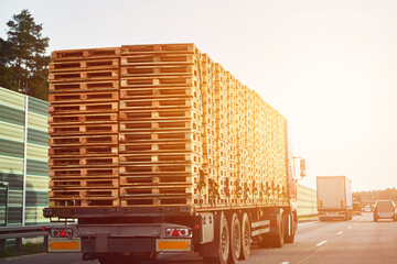 Side view of the Truck transporting a European pallet load on the highway. Truck Carrying European Pallet Load on the Road. Highway Cargo Delivery. - obrazy, fototapety, plakaty