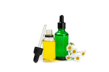 Glass bottle with chamomile essential oil isolated on white background. Chamomile flowers, close up. Aromatherapy, spa and herbal medicine ingredients. Beauty concept. Natural cosmetics