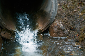 Draining sewage from a pipe into the river. Concept of pollution rivers and ecology. Water...