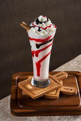 A cup of milkshakes with different flavors on a wooden floor