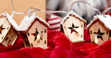 Luminous garland in the shape of wooden houses. Beautiful Christmas and New Year greeting card.