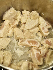 Close up of chicken cooking in a metal pan