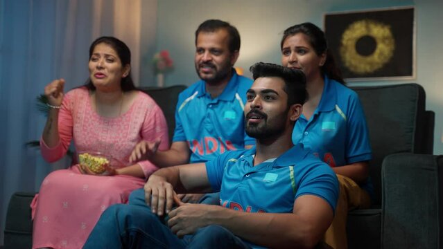 Group of family members celebrating team indias victory on cricket after eagerly waiting on tv or television - concept of world cup tournament, world cup tournament and intense sports