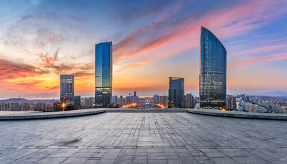 city square and skyline with modern buildings at sunset - obrazy, fototapety, plakaty