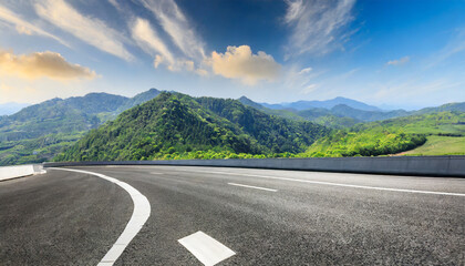 highway and green mountain landscape under blue sky