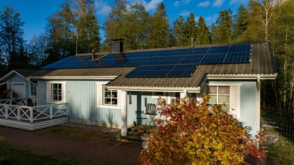 Aerial view in front of a modern home powered by sustainable energy, sunny autumn day