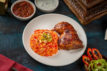 A plate of mandi rice with grilled chicken thigh