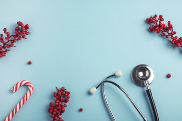 Medical stethoscope and Christmas festive decoration on pastel blue background. Christmas and New...