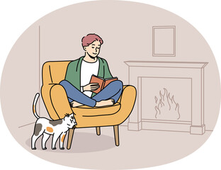 Happy man relax in chair near fireplace with book