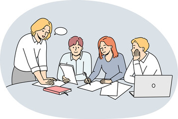 Businesspeople discuss paperwork at meeting