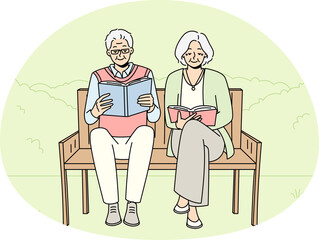 Mature couple on bench reading books