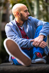 Madrid's bald, bearded gent, red-check shirt, strikes a cool bench pose.
