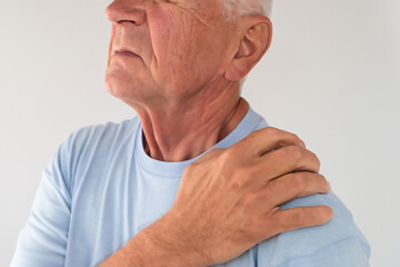 Fototapeta premium An elderly man experiences severe pain in the shoulder area. older man has problems with joints and muscles. body injury concept