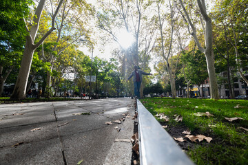 Madrid's autumn flair: Wide-angle shot captures man balancing on vibrant street.