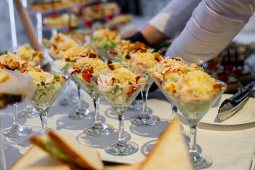 hands of a waiter prepare food for a buffet table in a restaurant