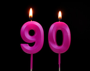 Burning birthday candles isolated on black background, number 90.