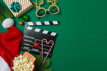 Christmas movie night and party concept with  popcorn, Santa hat, decorations and movie clapper...