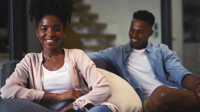 Woman, face or happy in marriage on couch, husband loyalty or security in smile in living room. Black couple, young or portrait by partner commitment, man in support or relax wellness in modern home