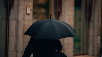 Person Holding Umbrella in the Rain for Wet Weather Protection