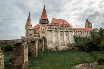 Fototapeta na wymiar a large castle in a green area with some grass on the ground: Corvin Castle Hunedoara Romania