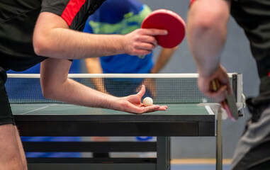 Table tennis player serving in a table tennis championship match