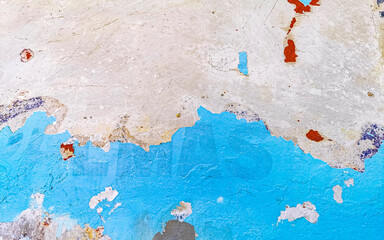 Old cracked blue painted wall with sloping sections in Mexico.