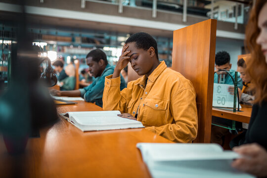 Young female student reading book in library. Woman focused on the page words deep in thought