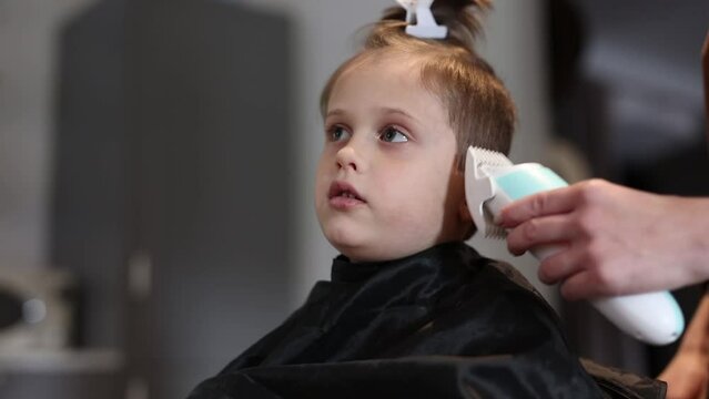 mom cuts her son hair with hair clipper at home, Poland