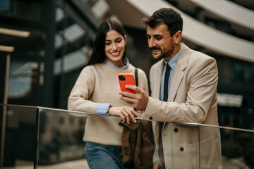 Shot of business colleagues arriving at the conference, standing and using a smartphone.