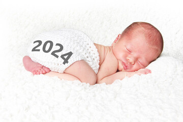 2024 Happy New Year baby. Newborn infant asleep on a white blanket on New Years day 