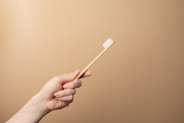 wooden toothbrush in hand on natural background, bamboo brush, environmental protection, garbage sorting