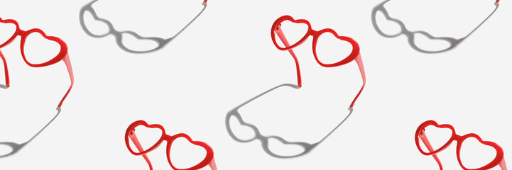 Pattern made with red heart shaped sunglasses on pastel color background