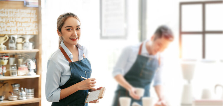 Smiling female waitress wear apron ready to take order on notepad in restaurant, serving staff good customer service