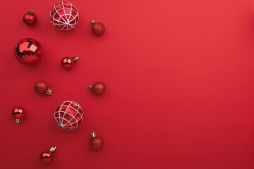 Red Christmas baubles decoration on red background with copy space