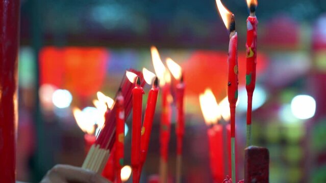 Blurry people in the Chinese temple praying to gods in city of Bangkok, Thailand.