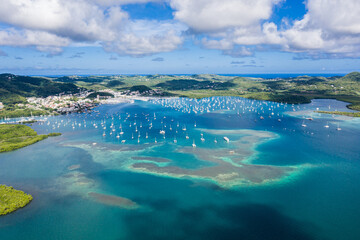 Yachts dotting Martinique's azure bay Vibrant Caribbean harbor from above - Powered by Adobe